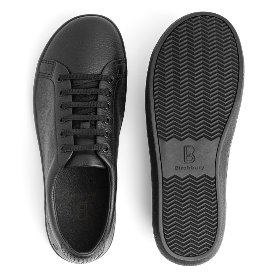 Birchbury black leather sneaker shown beside its black rubber sole