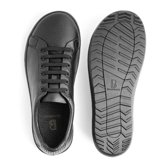 Birchbury black leather sneaker shown beside its non-slip rubber outsole