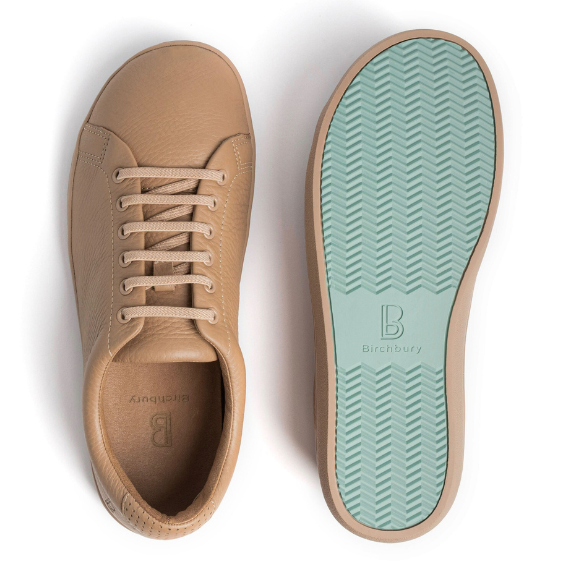 Birchbury tan leather sneaker shown beside its sage green rubber sole